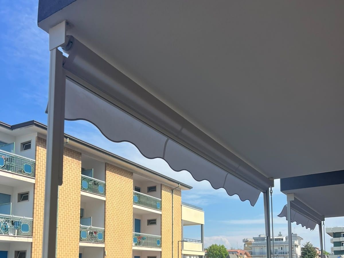 Tenda da sole con il bordo ondulato, vista da sotto contro il cielo di un balcone