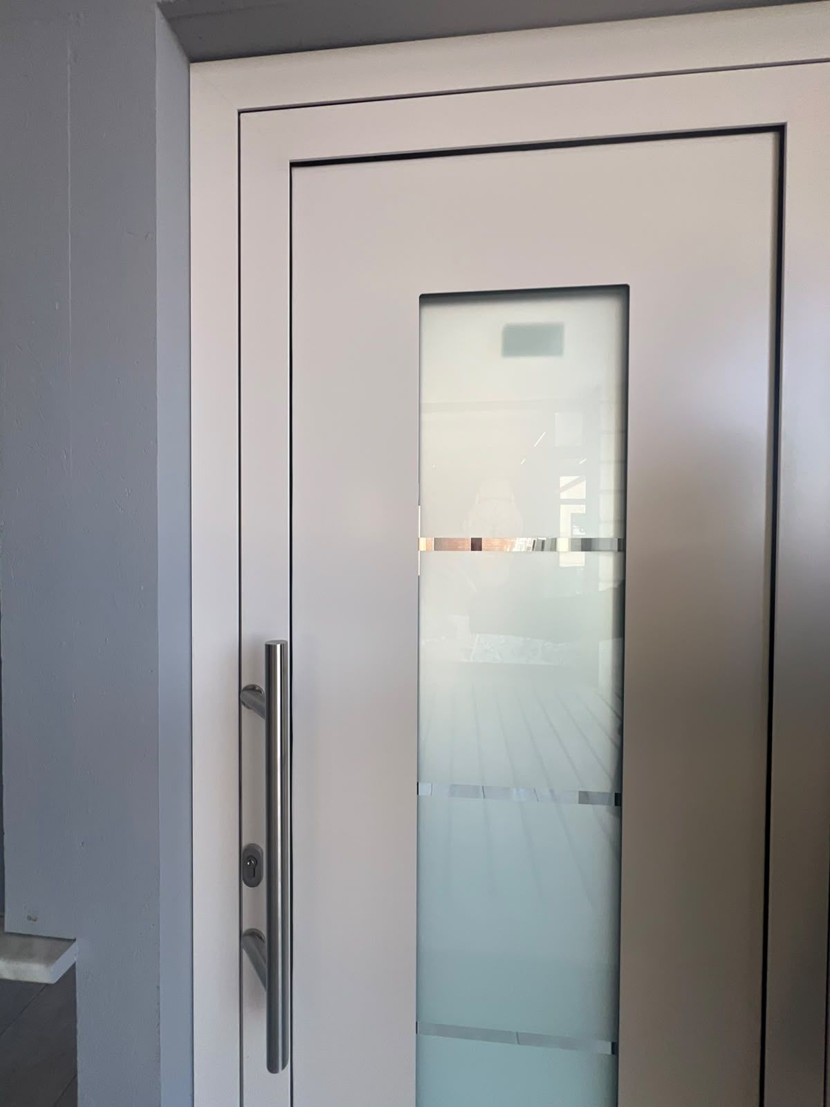 Portoncino d’ingresso bianco con vetro satinato a righe e maniglione